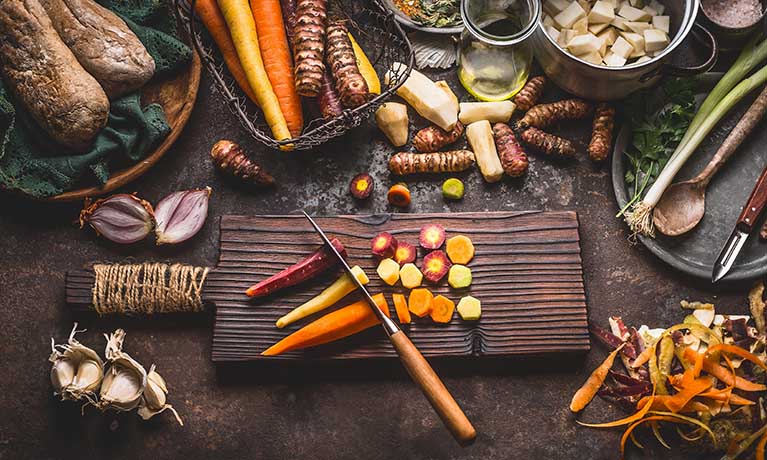 Selection of vegetables on a chopping board and table.