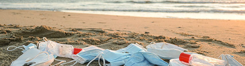 a pile of face masks on a beach