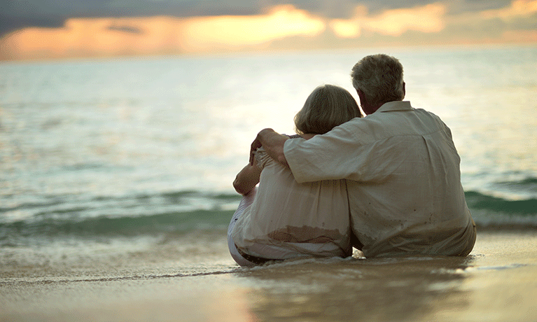 Elderly couple embracing on a beach