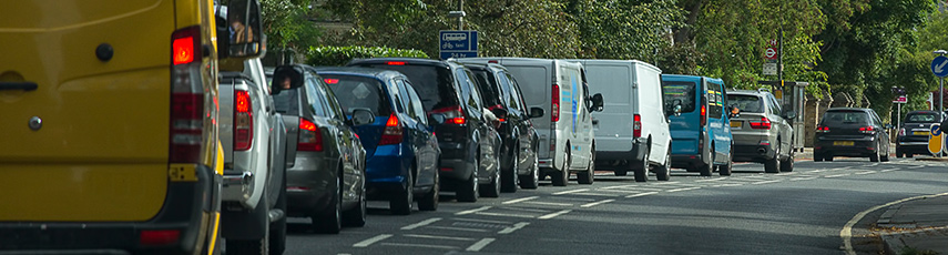 Cars and vans queuing in heavy traffic