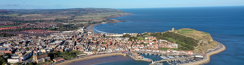 Aerial view of Scarborough showing the town, fields and sea