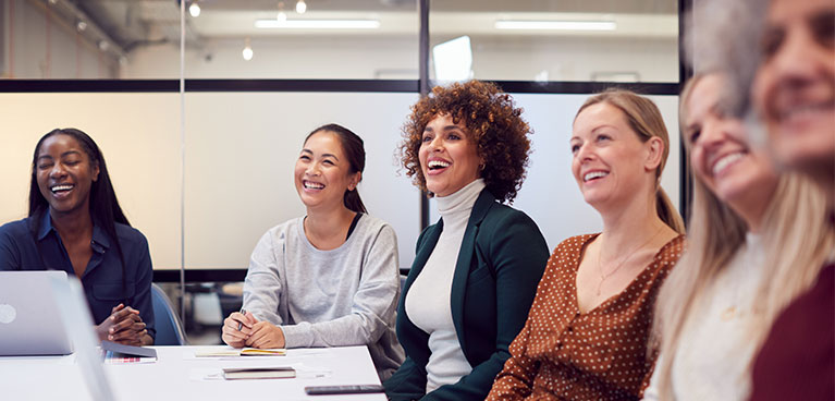 A group of women sitting around a boardroom table