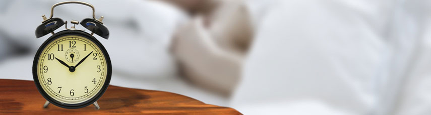 Clock next to a bed
