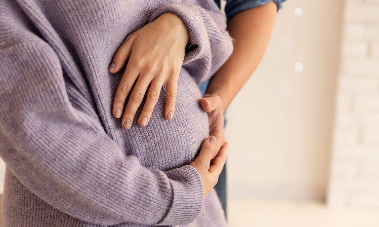 Pregnant woman cradling her belly