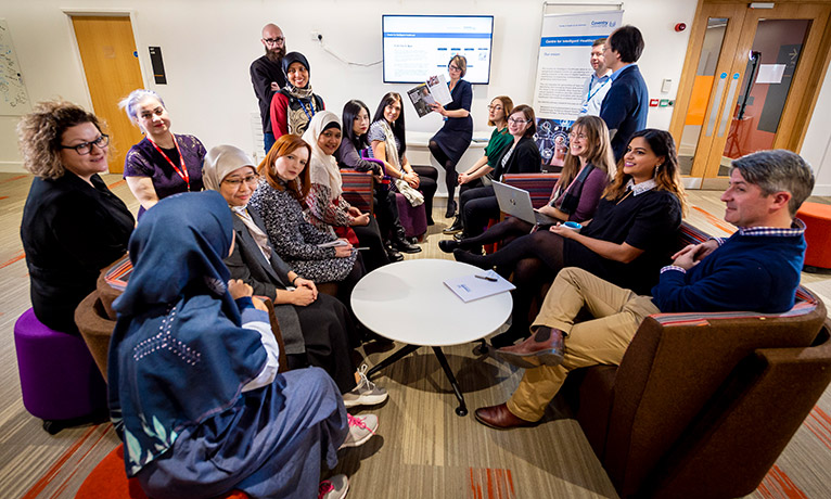 men and women sitting round a table in a room