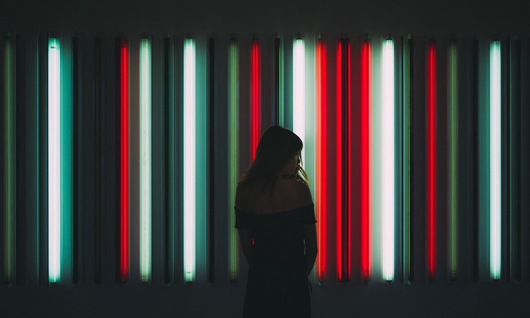 Woman standing against a backdrop of red black and white lines