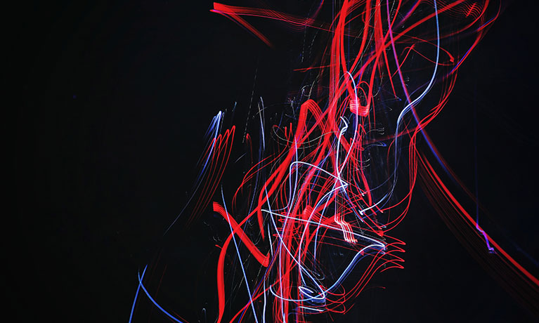 a black image with red, blue and white streaks on it