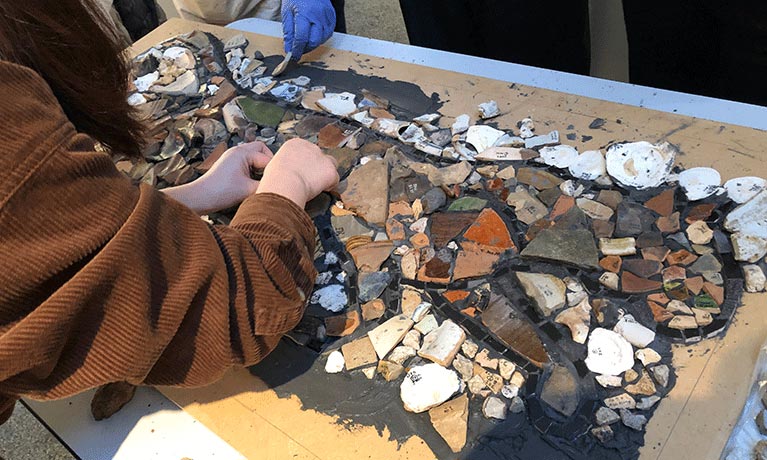 People making a collage from archaeological fragments