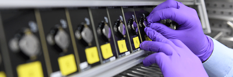 Technician in purple gloves adjusts dials on system