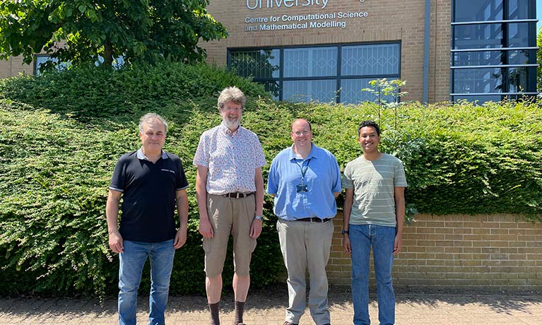 Four men from Coventry University and Maplesoft standing outside the Centre for Computational Science and Mathematical Modelling