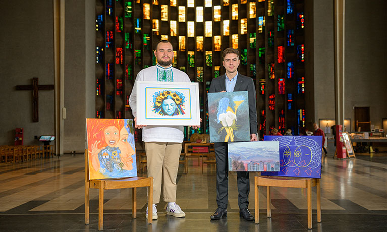 Left to right, Oleksandr Ignatiev and Pavel Pimkin with some of the paintings at Coventry Cathedral that will be on display at Coventry University’s RISING Global Peace Forum