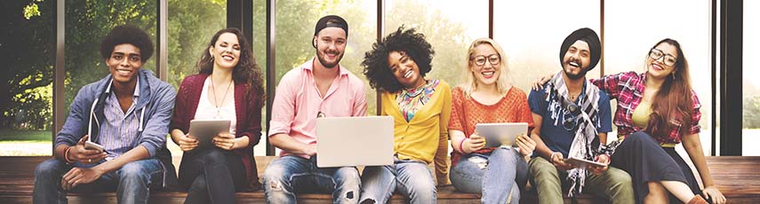 Diverse group of students sitting on a wall together.