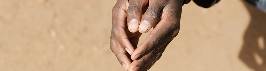 Man crouching with his hands together