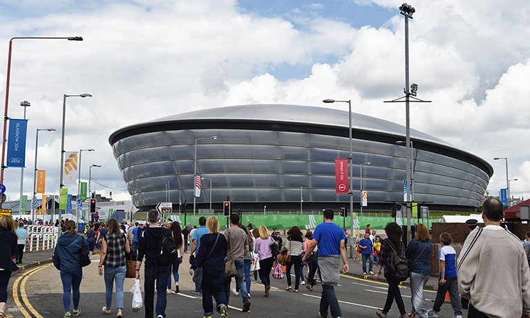 Crowds of people approaching the outside of a football stadium