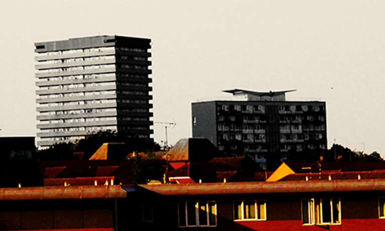A cityscape, prominently featuring a block of flats.
