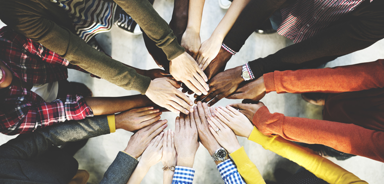 A group of people with their hands together in a huddle