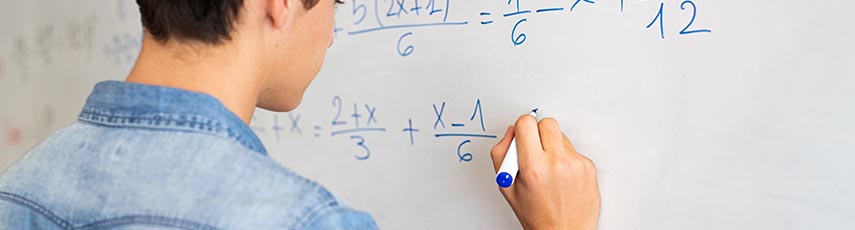 Young boy writing on whiteboard mathematic equations