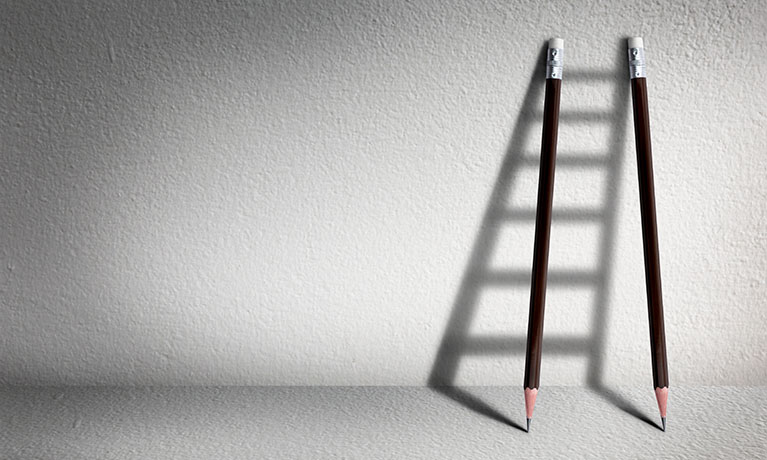 Black ladder leaning against a white wall
