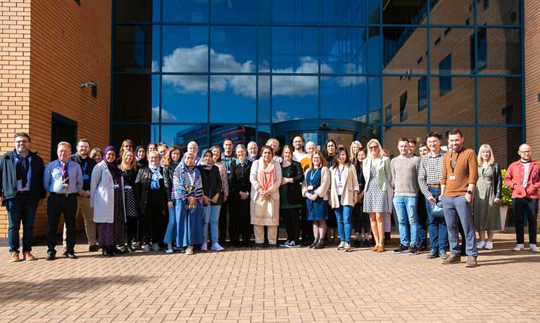 Members of the Global Learning community stood outside conference building in sunshine