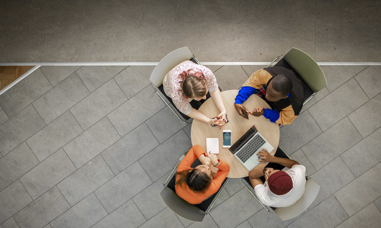 Aerial shot of four students working at round table