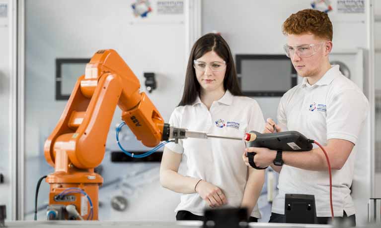 white female and male students working with cobot