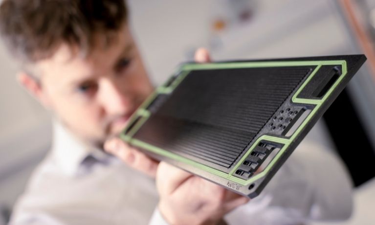 close of of a black and green circuit board with an out of focus person inspecting it lab close of of a black and green circuit board with an out of focus person inspecting it lab