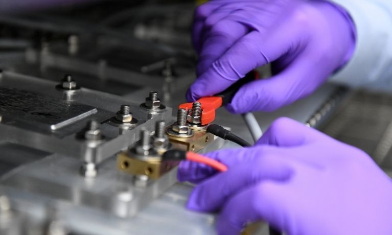 close up of a pair of hands in bright purple gloves twisting dials in a lab setting close up of a pair of hands in bright purple gloves twisting dials in a lab setting