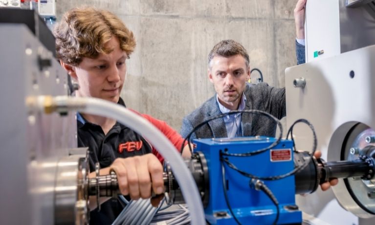 young student is shown how to use machines by professor