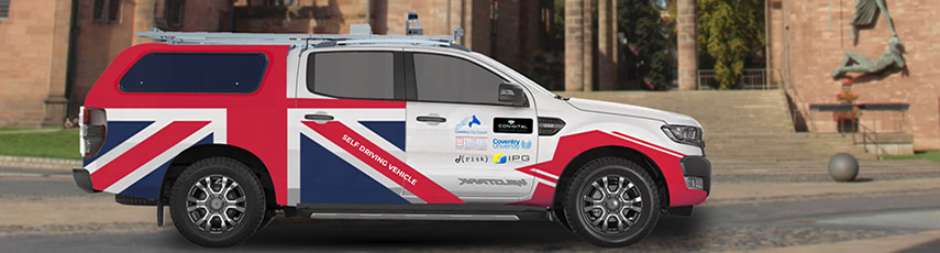 A self-driving vehicle printed with a large Union Jack flag across the back of it.