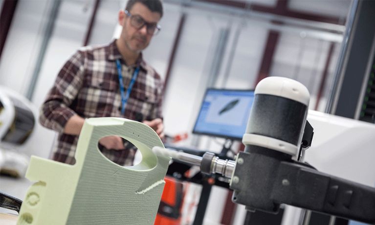A man in a checked shirt using a CNC milling machine A man in a checked shirt using a CNC milling machine