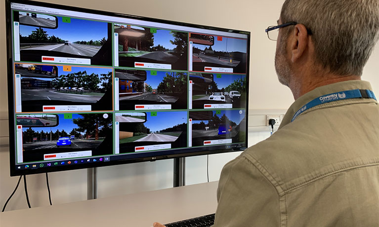 Person monitoring self-driving vehicles on a screen