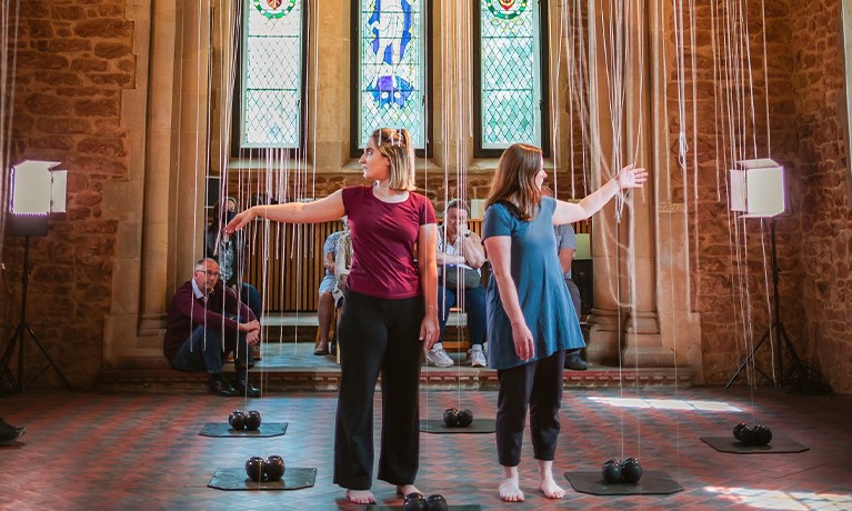 Two women dancing with their arms in the air.