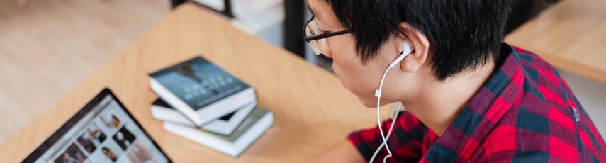 Student working on a laptop with headphones on