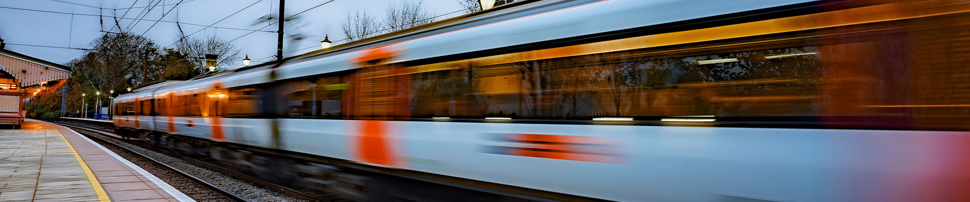 Commuter train departing a station at dusk