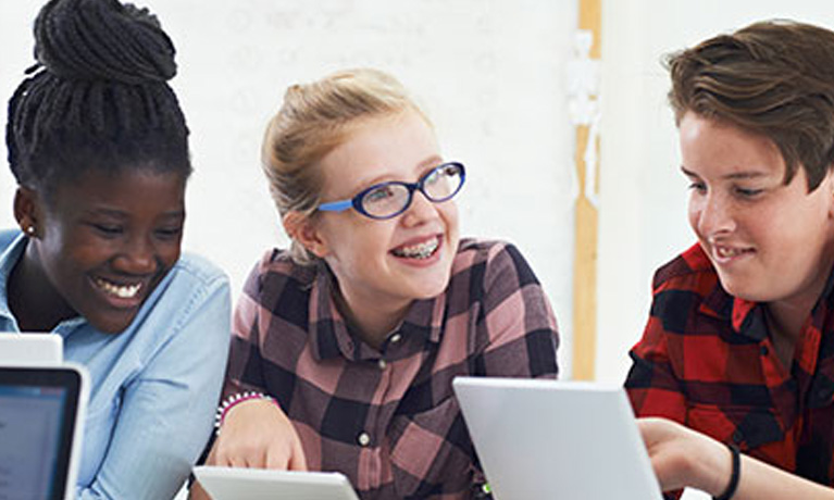 Young people smiling while using their tablets