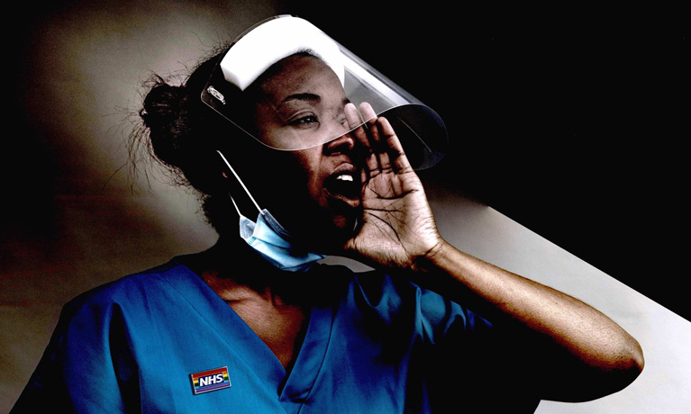A still from the doumentary of a black woman nurse wearing scrubs and PPE. She is holding her hand up to cup her mouth to shout something.