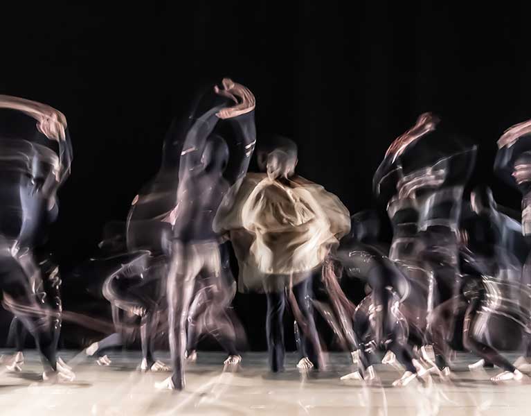 blurry dancers dancing with black background