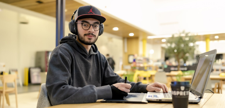 Student using a laptop in The Hub
