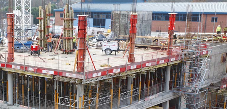 Erecting a new multi-level building with workers on the top level.