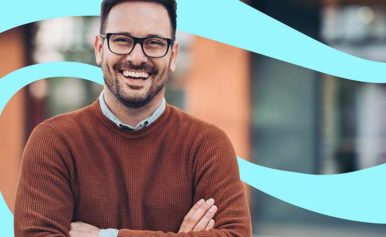 Smiling man with his arms crossed standing outside a building with light blue swirl graphic overlay