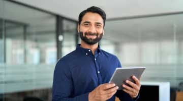 Man holding a tablet smiling at the camera