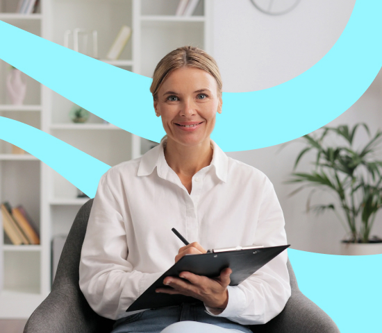 Woman sitting in a chair holding a clipboard and smiling in a bright, modern room.