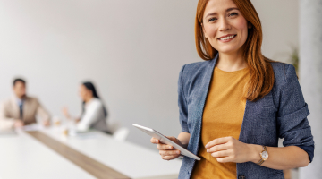 Woman holding a tablet smiling at camera