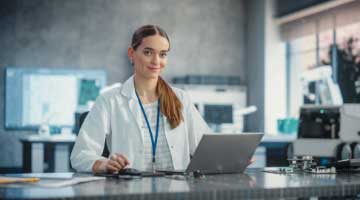 student wearing a lanyard in front of a laptop