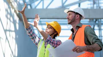 Two engineers looking at scaffolding in a construction site