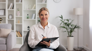 Woman with clipboard smiles while writing