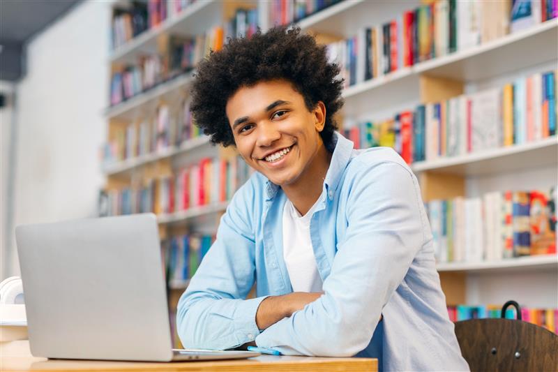 Smiling young man sitting in front laptop