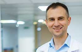 medical professional in a white coat smiling at the camera