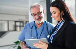 older male nurse looking at a tablet with a woman wearing a suit