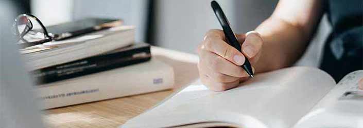 Close up of a person writing in a notebook